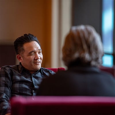 A man having a thoughtful conversation with others.